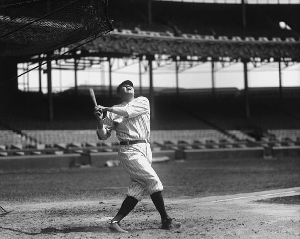 Babe Ruth watching a ball he just hit fly into the air
