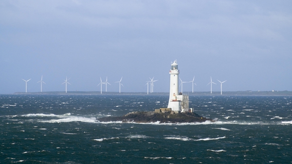 Tuskar Rock lighthouse, off the coast of Wexford, with Carnsore wind farm in the background