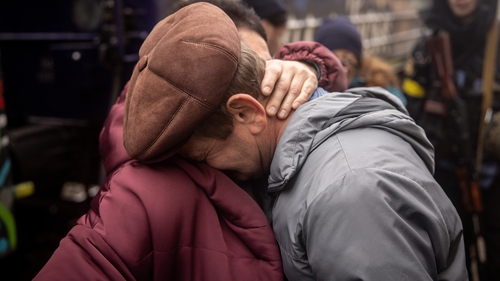 Mykola Desiatnikov (R) hugs his wife Liudmyla, who arrived on the first train to arrive back to Kherson Railway station