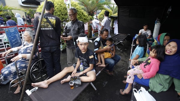 Wounded people rest under a tent outside a hospital in Cianjur following the earthquake