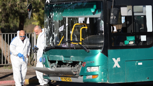 Forensic teams examine the scene of one of the blasts