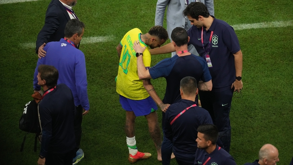 Neymar receives attention on his injured ankle following his late substitution