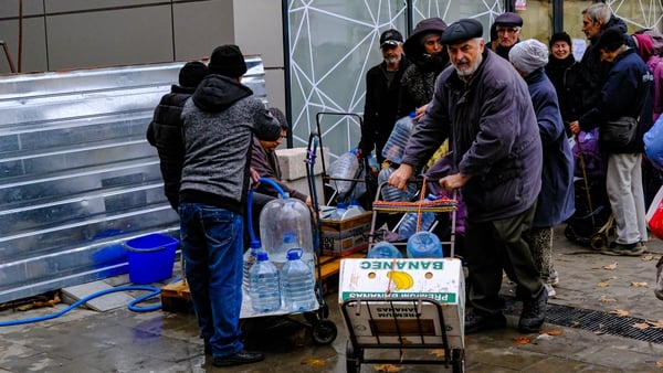Ukrainians collect water from an aid centre as water shortage continues in Kherson