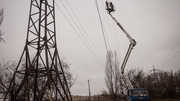 Electricity workers attempt to fix a destroyed high voltage power line in the Kherson region