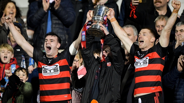Ballygunner joint captains Dessie Hutchinson (L) and Ian Kenny lift the cup with supporter Tom Millane