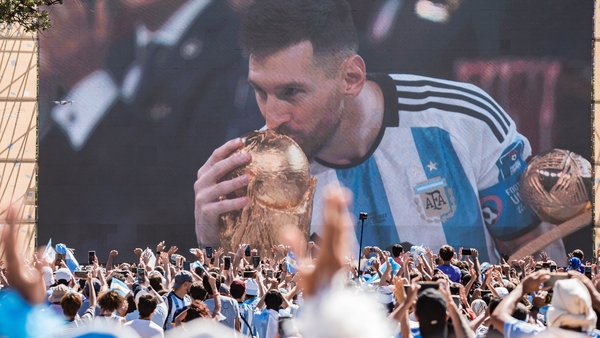 Lionel Messi kisses the World Cup as thousands watch on a big screen back in Buenos Aires