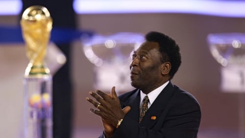 Pele applauds as he stands next to the trophy in Leipzig during the final draw ceremony for the 2006 World Cup