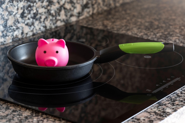 concept of saving energy with piggy bank and cooking utensil