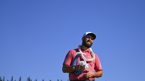 Jon Rahm poses with the trophy in Hawaii