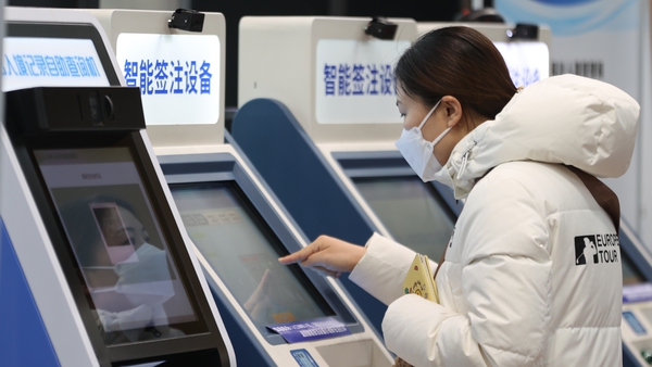 A woman fills out a travel application form at the Exit and Entry Service Center in Beijing