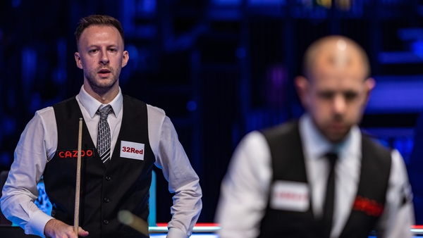 Judd Trump looks on during his quarter-final with Barry Hawkins at the table
