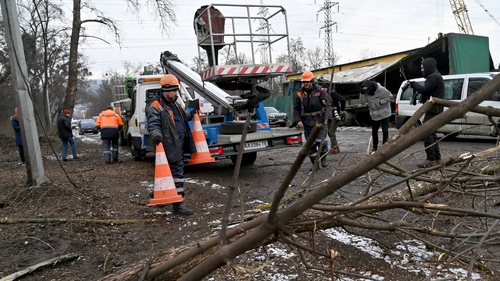 Workers repair power lines following a Russian missile strike on the industrial zone of Kyiv today