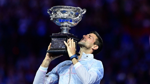 Novak Djokovic hoists the trophy in Melbourne