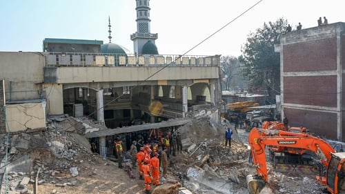 Rescue workers search the ruins of a mosque the day after a blast in Peshawar, Pakistan