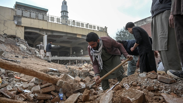 Men clear debris in the aftermath of Monday's bomb attack