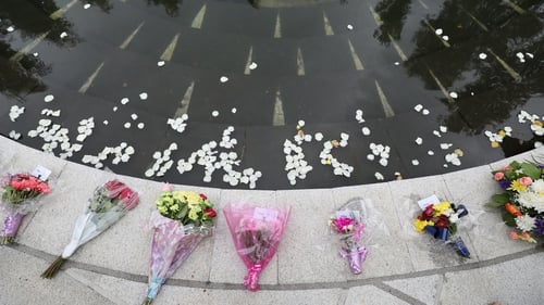 White Rose petals are thrown into a pond at the Omagh Memorial Garden during a recent anniversary ceremony