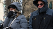 People bundle up as they shield themselves from cold winds in New York City