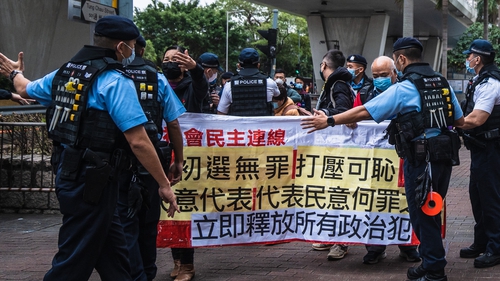 Members of the League of Social Democrats hold a banner outside the West Kowloon Magistrates' Courts