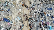 Aerial view shows residents searching for victims and survivors amidst the rubble of collapsed buildings in the village of Besnia in Syria's rebel-held northwestern Idlib province
