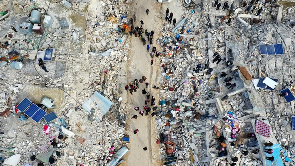 Aerial view shows residents searching for victims and survivors amidst the rubble of collapsed buildings in the village of Besnia in Syria's rebel-held northwestern Idlib province