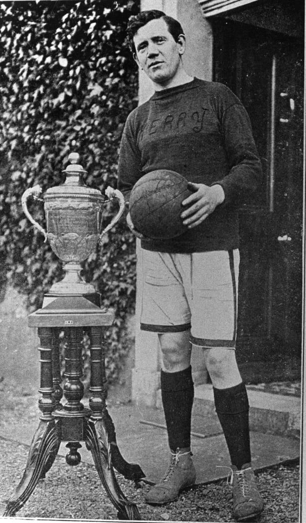 Black and white photograph of Dick Fitzgerald standing beside the Doctor Croke Football Cup