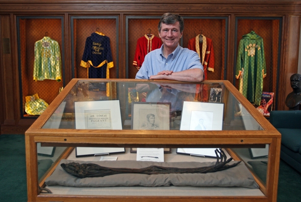 (073108 Chestnut Hill, MA) Robert O'Neill of the Burns Library poses in front of the mummified arm if Irish boxing great Dan Donnelly at the Fighting Irishmen boxing exhibit at the Burns Library at Boston College. Behind him are some robes of some of the greats. Thursday, July 31, 2008. Staff Photo by Matthew West. (Photo by Matthew West/MediaNews Group/Boston Herald via Getty Images)