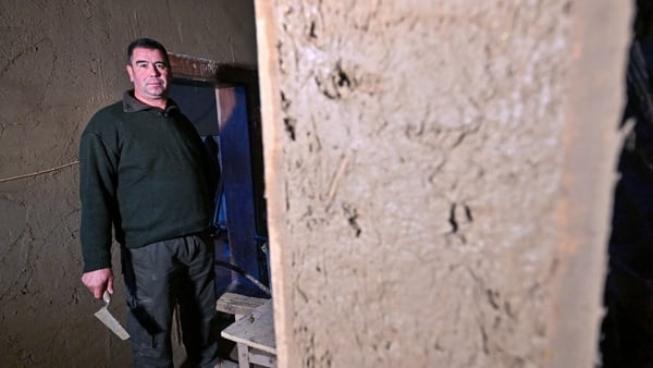Master builder Janos Gaspar poses inside a mud-brick house in Acs, northwestern Hungary