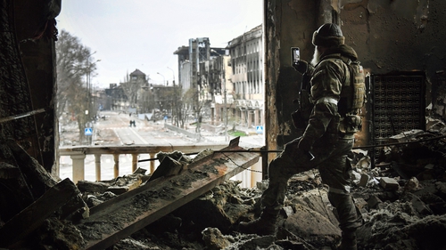 A Russian soldier patrols at the Mariupol drama theatre, bombed 16 March, 2022