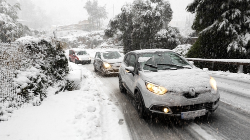 Cars travel on a snow-covered road close to the mountain village of Valldemossa on Mallorca