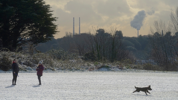 People walk their dogs after snowfall in Finglas, Dublin