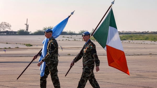 Irish peacekeepers of the United Nations Interim Force in Lebanon (UNIFIL) walk with the UN and Irish flags