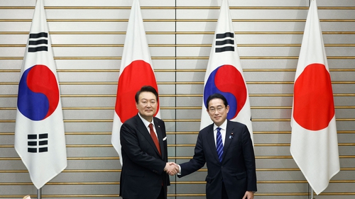 South Korea's President Yoon Suk Yeol (L) and Japan's Prime Minister Fumio Kishida shake hands ahead of a summit meeting at the prime minister's official residence in Tokyo