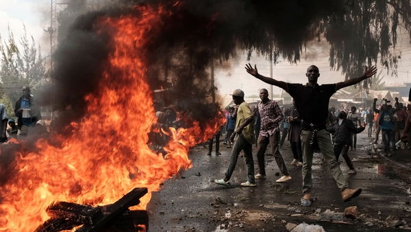 A protestor gestures next to a burning barricade during a mass rally called by the opposition leader Raila Odinga who claims the last Kenyan presidential election was stolen from him and blames the government for the hike of living costs in Kibera, Nairob