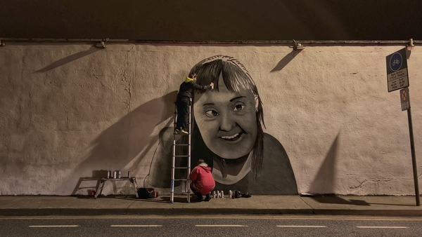 Street artist Emmalene Blake paints a mural of her cousin in Dublin to mark World Down Syndrome Day.