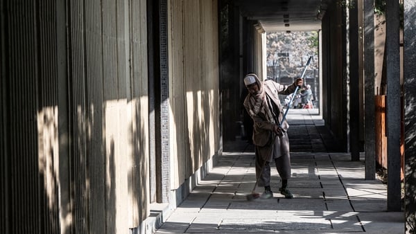 A worker cleans the corridor of Esteqlal High School in Kabul