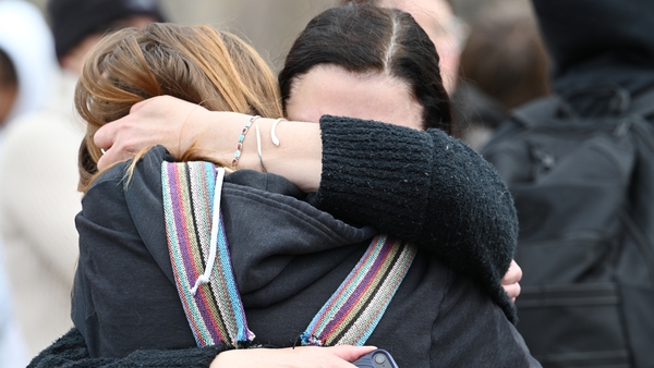 Addison Goetz, aged 17, is embraced by her mother Jennifer as they leave Denver's East High School after a shooting there yesterday