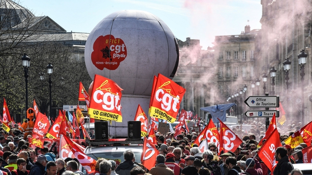 Des manifestants brandissent des drapeaux de la confédération syndicale CGT et FO alors qu'ils participent à une manifestation à Bordeaux