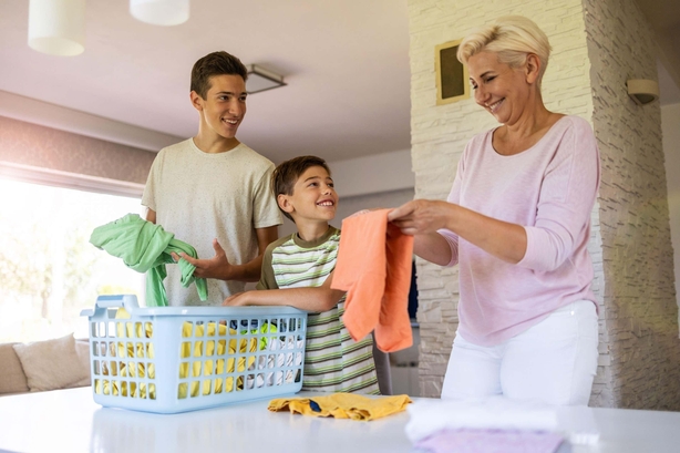 Mother doing laundry with two young sons