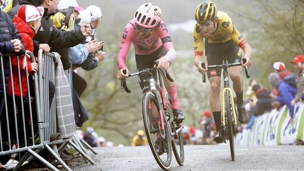 Ben Healy (pink) grimaces on a hilly climb