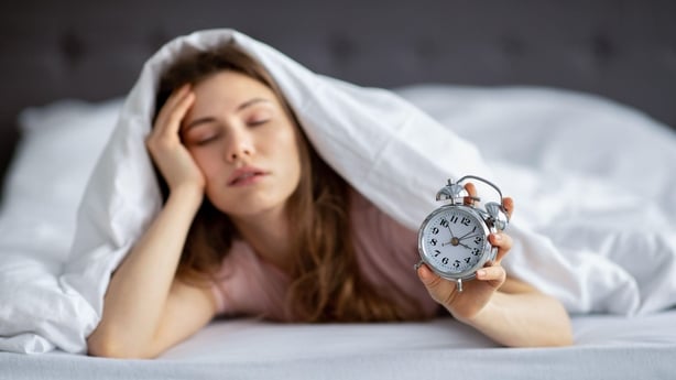 Woman waking in night and clock watching