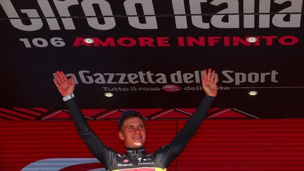Remco Evenepoel celebrates on the podium after winning the first stage