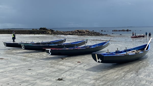The traditional racing currachs on the beach before entering the water