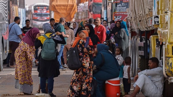 Passengers fleeing war-torn Sudan rest before crossing into Egypt through the Argeen Land Port