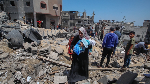 Palestinians inspect the damage of a house hit by the Israeli airstrikes at Beit Lahia