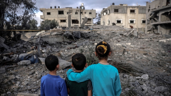 Children stand amidst the rubble of a building hit by an Israeli air strike in Deir al-Balah in the centre of Gaza