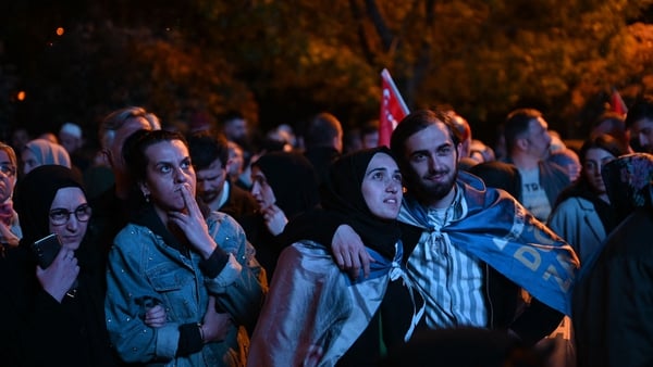 Supporters of Turkish President Recep Tayyip Erdogan look at early presidential election results displayed on a screen in front of the Justice and development Party headquarters