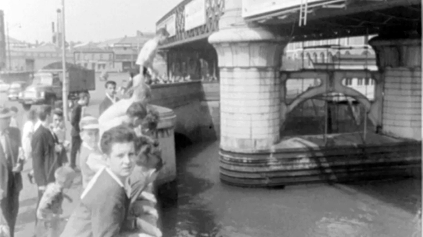 A boy prepares to jump off Butt Bridge into the River Liffey in Dublin, 1963