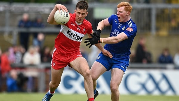 Derry forward Shane McGuigan holds off the challenge of Monaghan defender Ryan O'Toole