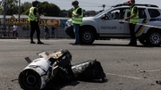 Police at the scene as debris lies on a road after Kyiv came under attack