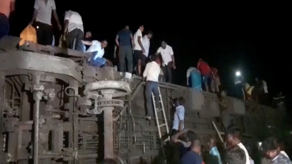 People try to escape from toppled compartments following the deadly collision of two trains in Balasore, India